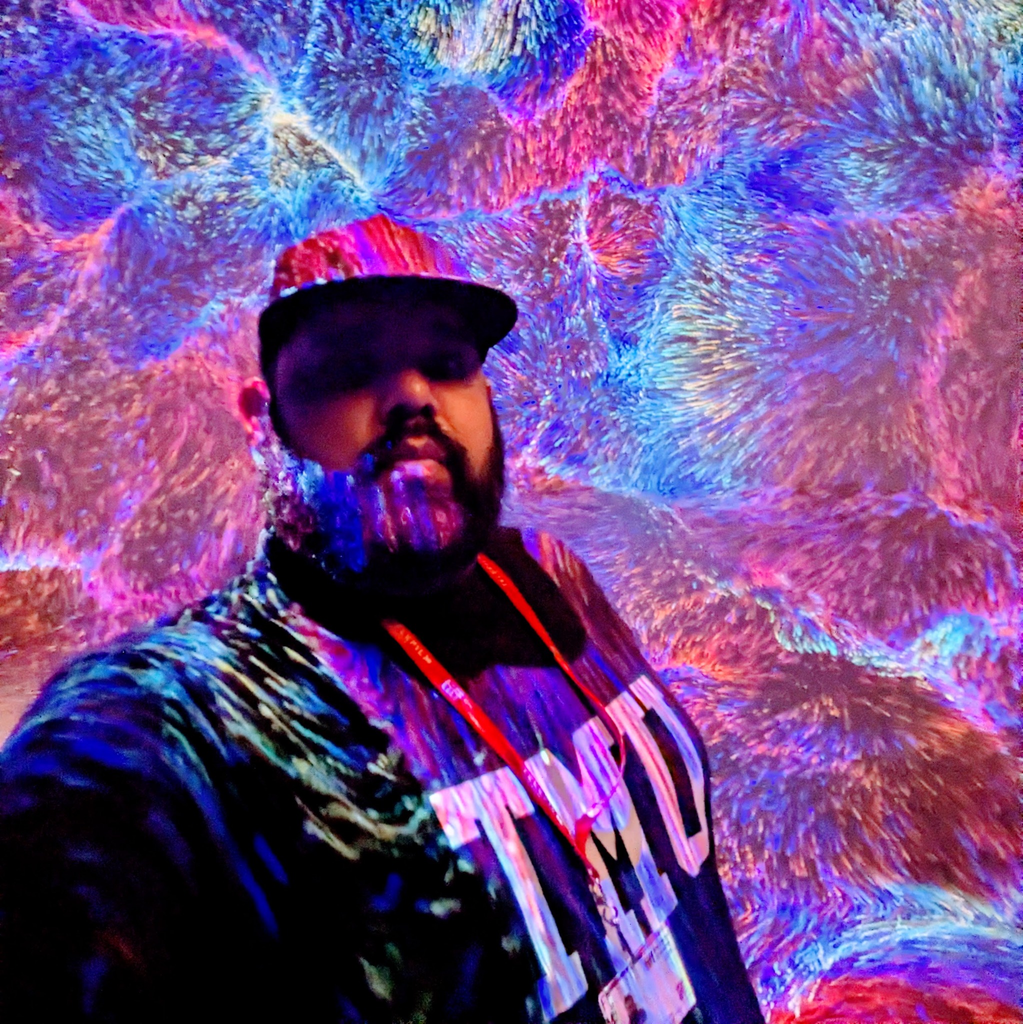 Anson Aswat surrounded by blue, violet and pink projected light